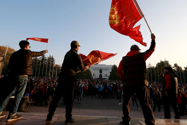 Supporters of Kyrgyzstan's new president Sadyr Japorov on the streets waving the national flag.