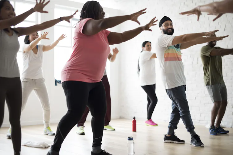 Group of people dancing in a gym.