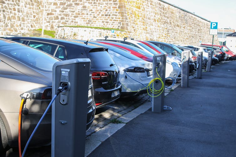 Cars lined up on a city street charging.