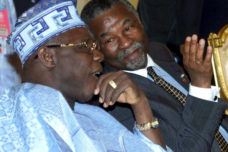 President Obasanjo, left, wearing a blue flowing Nigerian garb and matching hat, with Thabo Mbeki, wearing a dark grey suit and a black and gold check tie