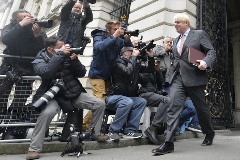 Boris Johnson cheerfully greets the press.