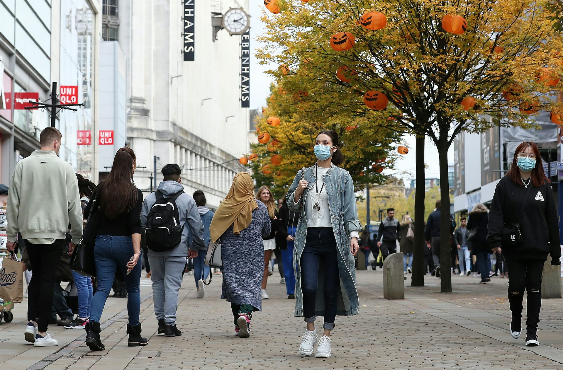 Six people walk down a pedestrianised street.