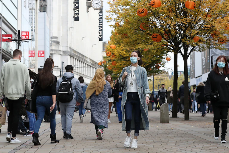 Six people walk down a pedestrianised street.