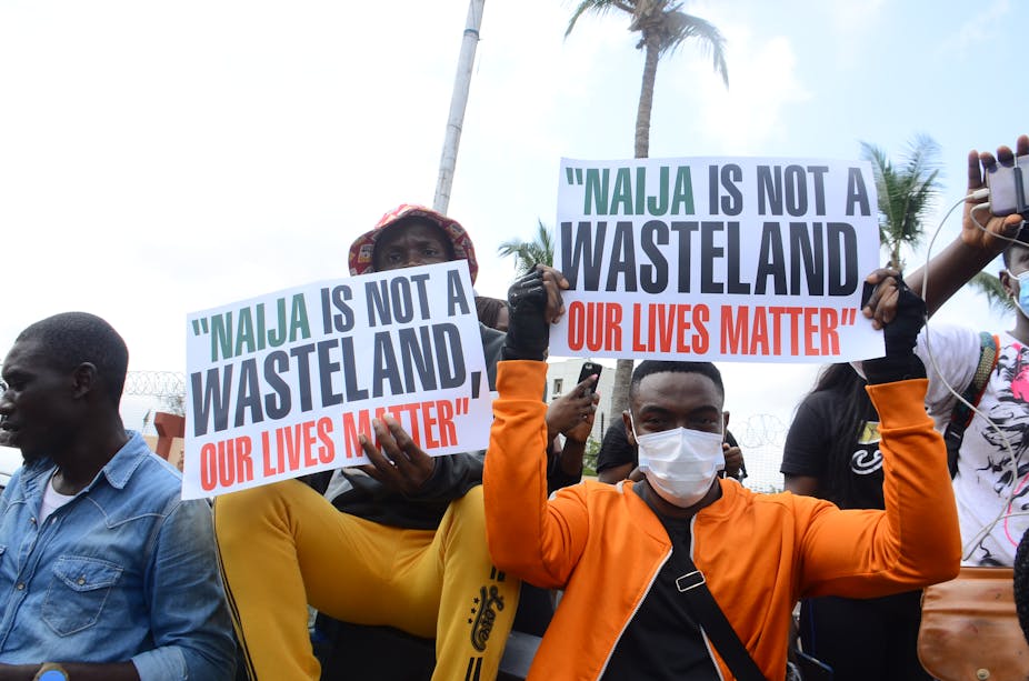 A group of young Nigerians holding placards saying that Nigeria is not a wasteland during an EndSARS protest in Lagos.