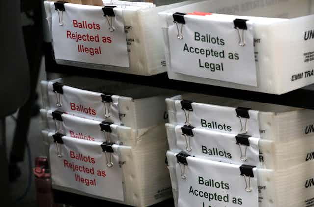 Florida ballots are placed in boxes labeled 'Rejected as Illegal' and 'Accepted as Legal'