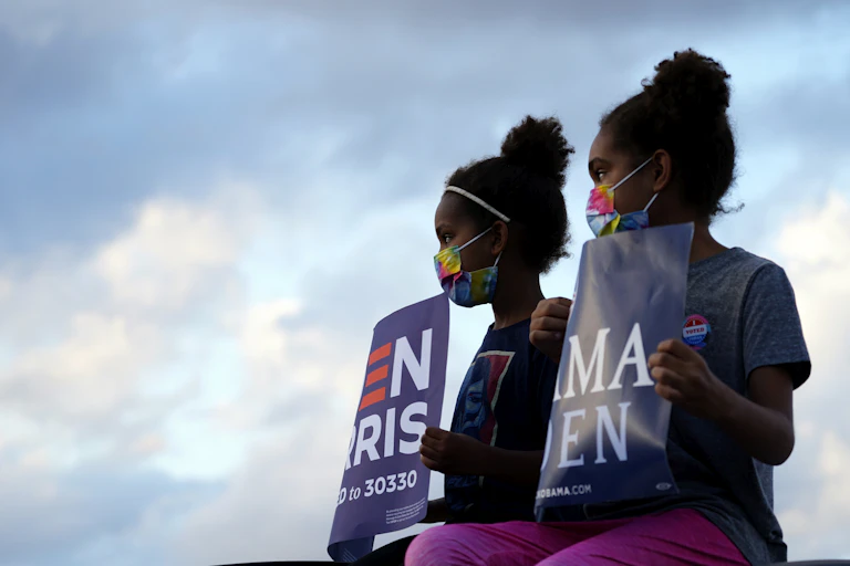 Two children holding Democratic party political signs.