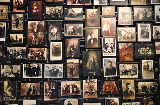 Wall of photographs showing Jewish people in the 1940s in a family setting.