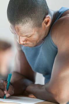 Black man concentrates while completing a form.