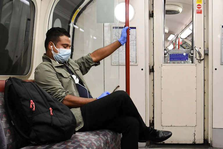 A man on the London Underground, holding on a pole