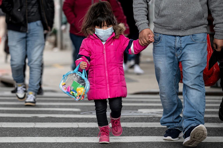 A small girl wearing a mask.