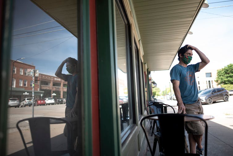 A cafe owner wears a protective face mask in Stillwater, Oklahoma.