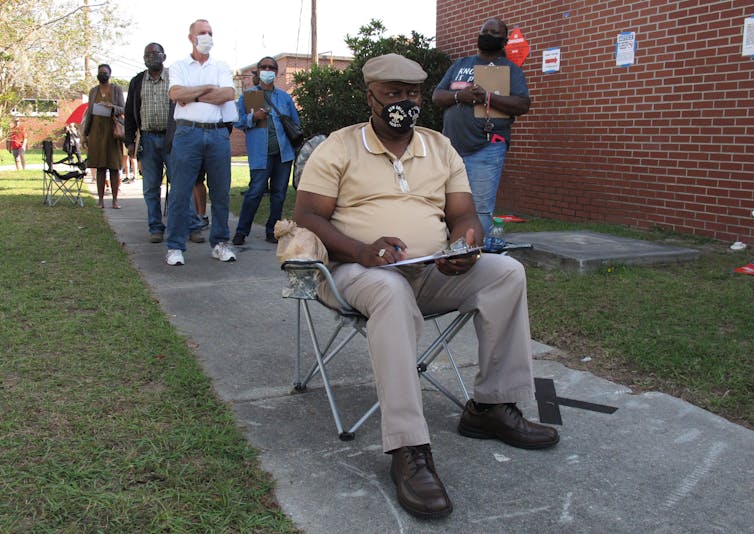 A man sits in a folding chair, waiting to vote in Savannah, Georgia
