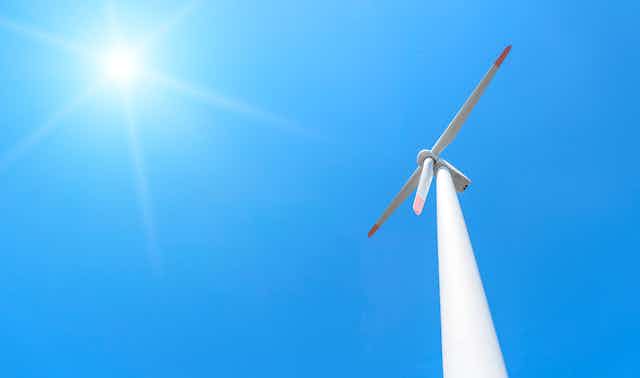 wind turbine against blue sky and sun