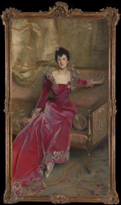 19th-century portrait of woman in a red dress sitting on a chaise Longue.