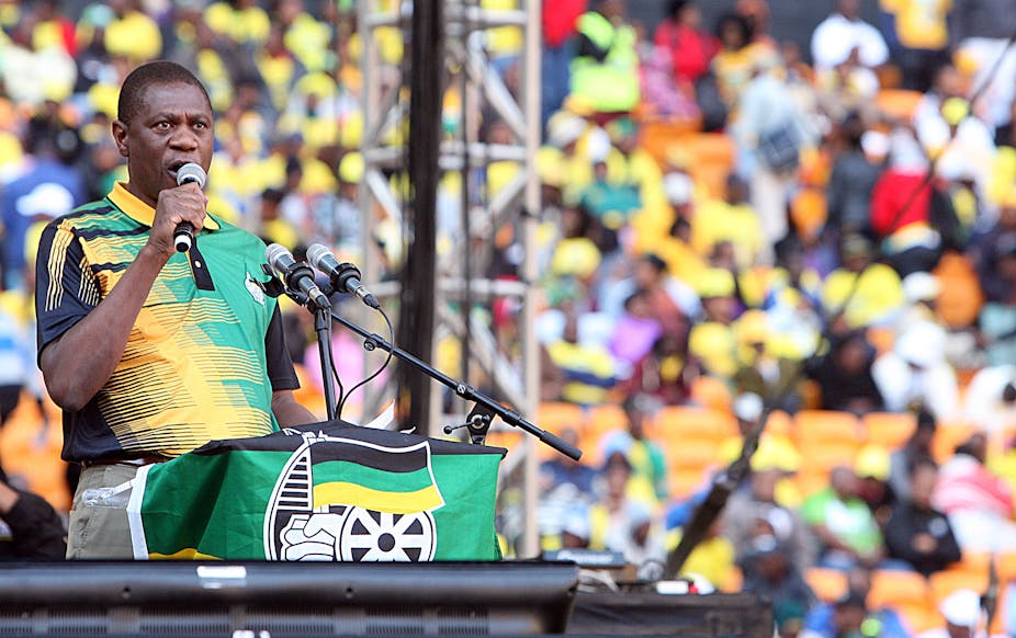 Paul Mashatile, wearing a golf shirt in the black, green and gold colours of the African National Congress that governs South Africa, speaks into a hand-held microphone at a political rally in Johannesburg. 