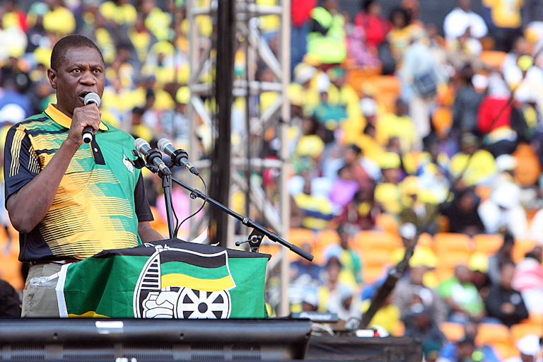 Paul Mashatile, wearing a golf shirt in the black, green and gold colours of the African National Congress that governs South Africa, speaks into a hand-held microphone at a political rally in Johannesburg.