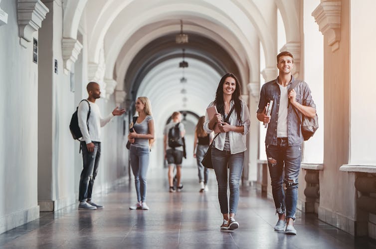 Students in a white hallway.