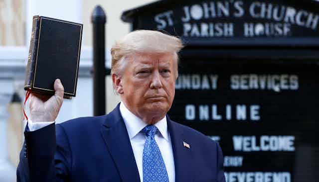 Donald Trump holds a bible up.