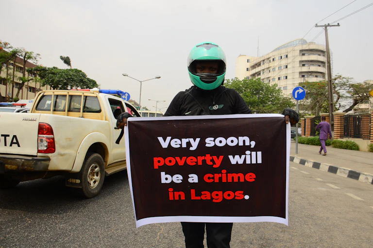 A man holds a placard reading ''Very soon poverty will a crime in Lagos''