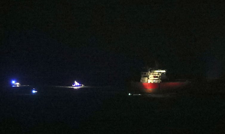 A red and white ship in the darkness.