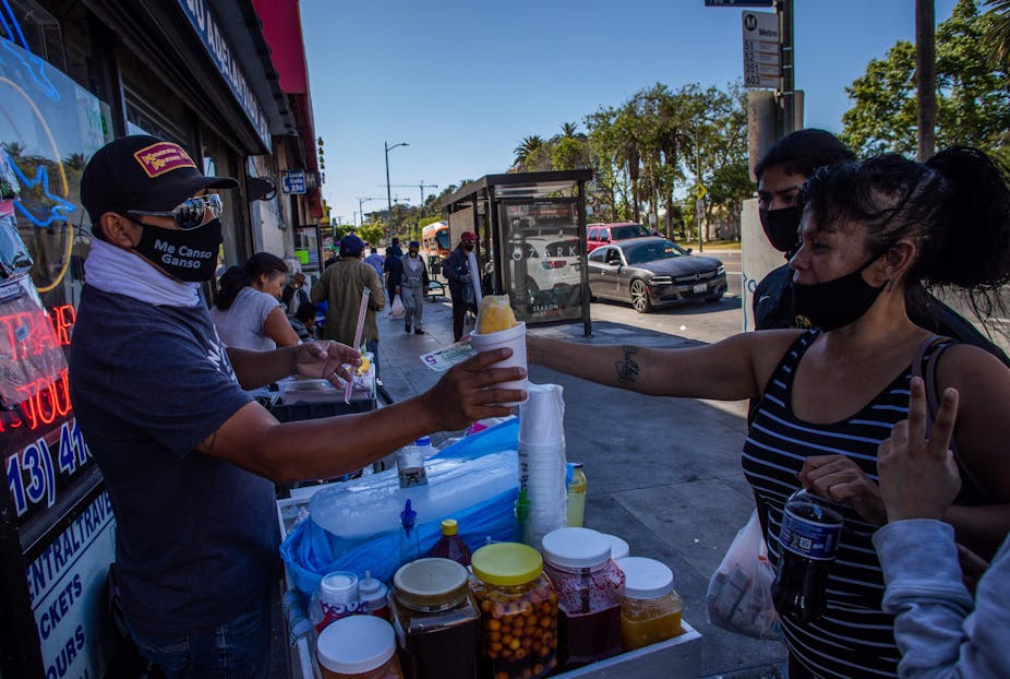 Street vendor hands food to clients on a California street