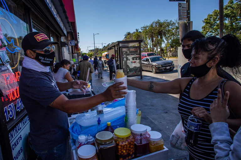 Street vendor hands food to clients on a California street