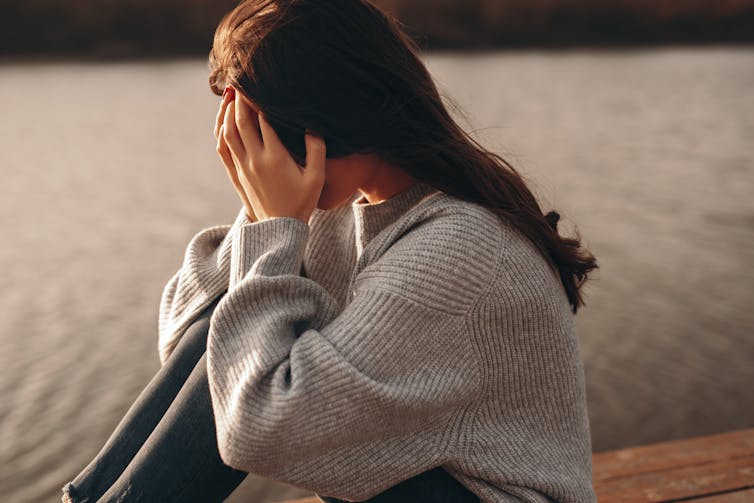 Unhappy woman with face in hands