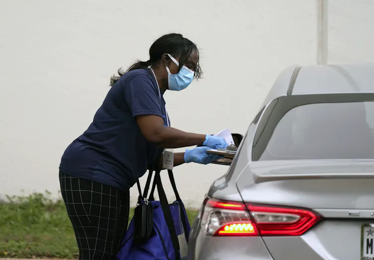 A Texas voter drops off an absentee ballot