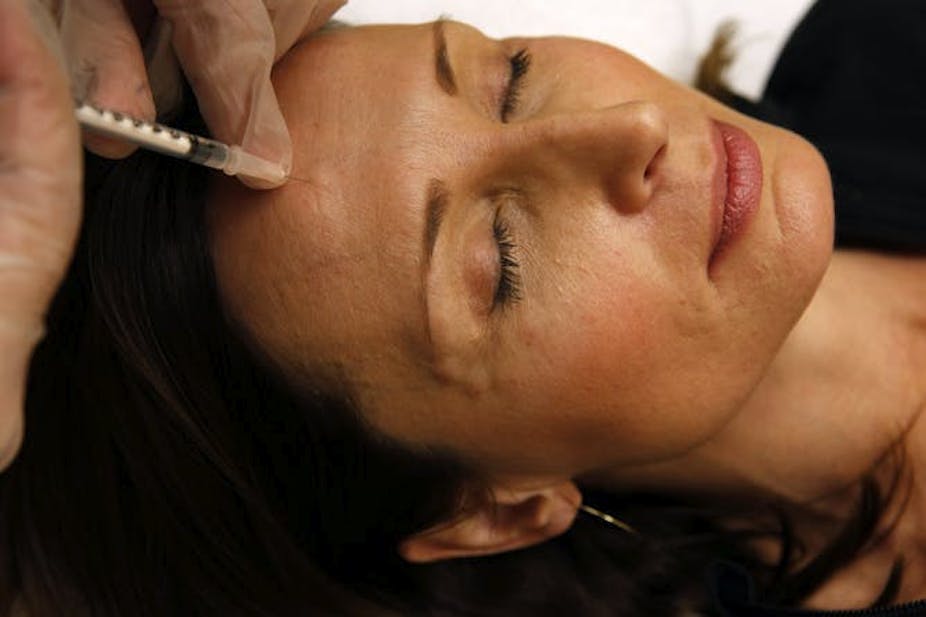 Woman receives an injection in her forehead