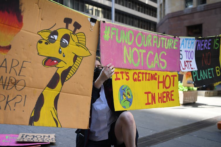 Students at a rally holding a sign against gas.