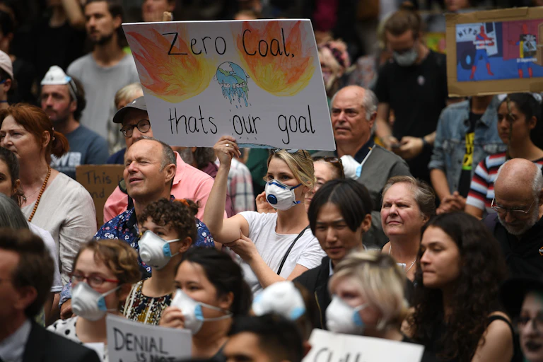A protestor holds up a sign saying "zero coal that's our goal"