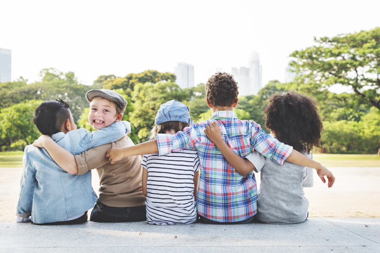Children of different ethnicities sitting by a river