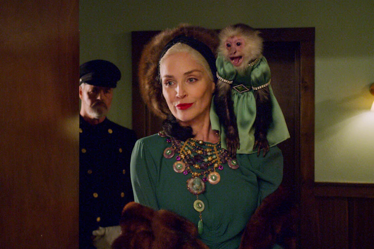 Expensively dressed woman with monkey on her shoulder.
