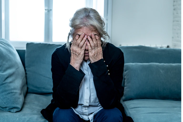 Lonely depressed senior old widow woman crying on couch in isolation at home