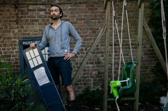 Actor David Tennant with a model of Doctor Who's Tardis in his garden.