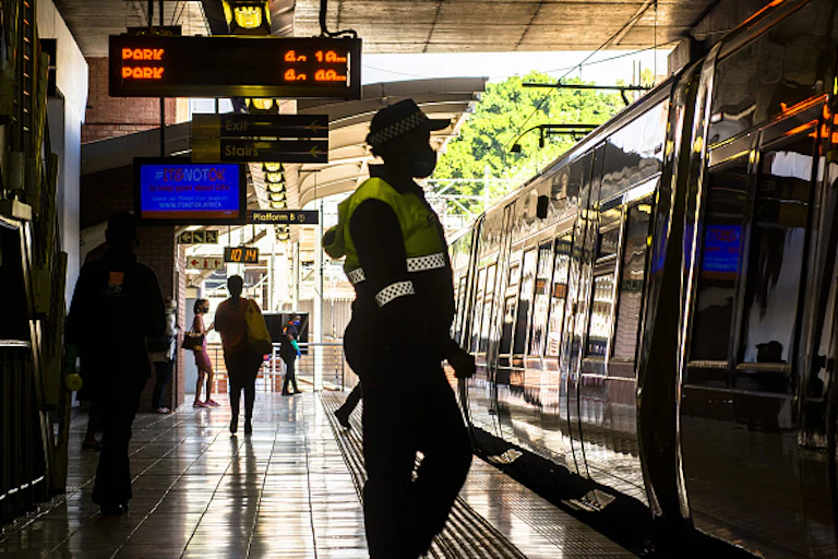 People standing on a station platform where a train is waiting