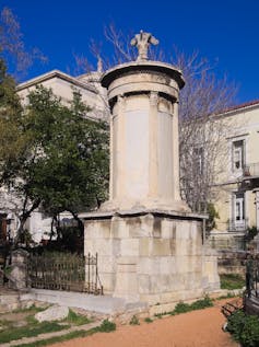 A photo showing a tall, cylindrical monument with elaborate carvings.