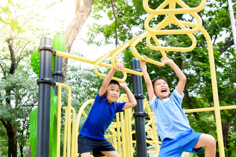 Two boys on monkey bars.