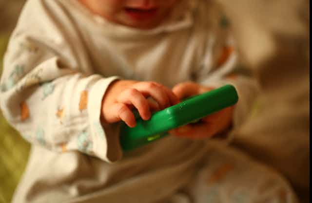 Baby holding electronic device