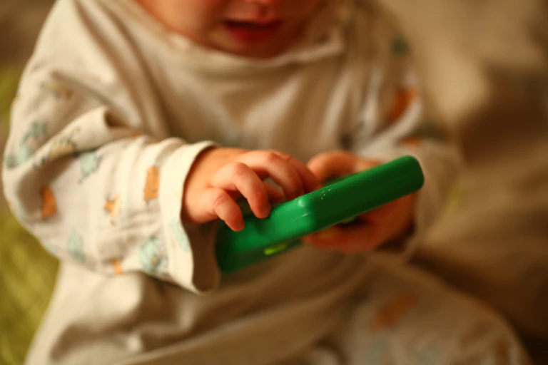 Baby holding electronic device