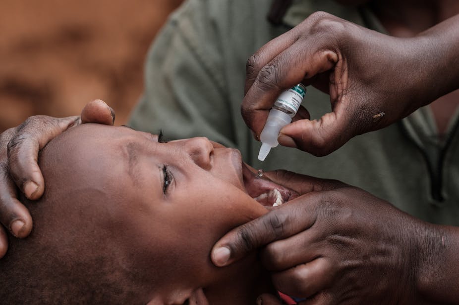 a crying child receives a polio vaccine 