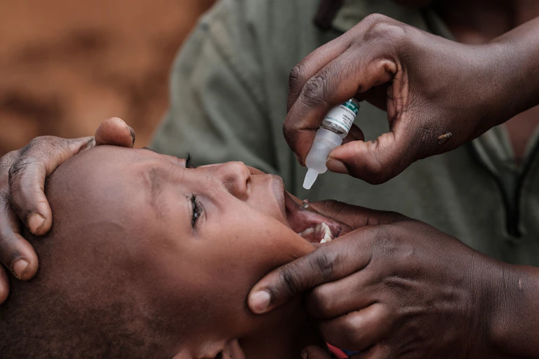 a crying child receives a polio vaccine