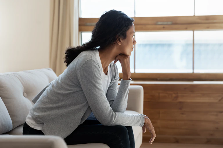 Woman staring out the window looking sad