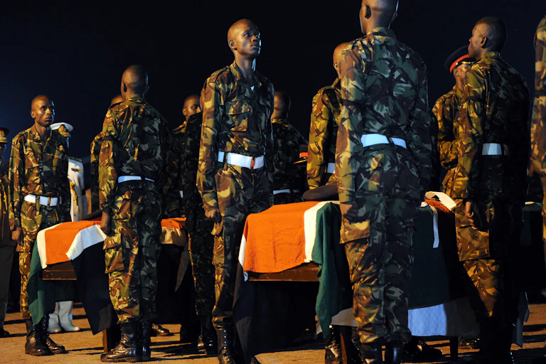Soldiers stand guard over flag-draped coffins