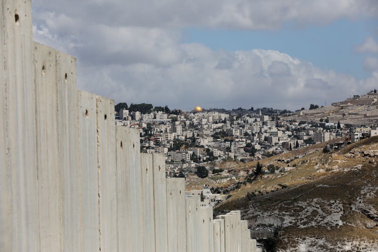 Large wall with Jerusalem in the background.