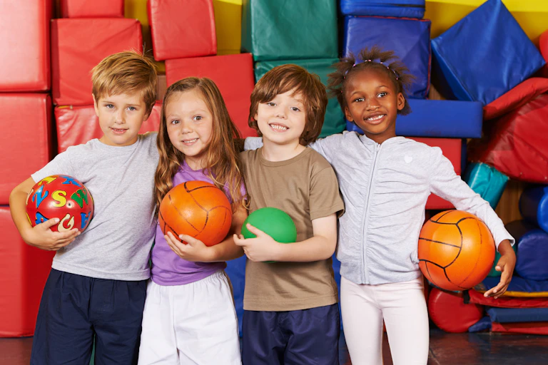 Children together in sports hall with balls