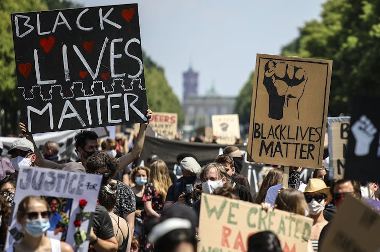 Protesers holding Black Lives Matter posters in Berlin.