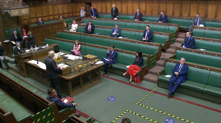 Members of parliament sit in the House of Commons chamber.