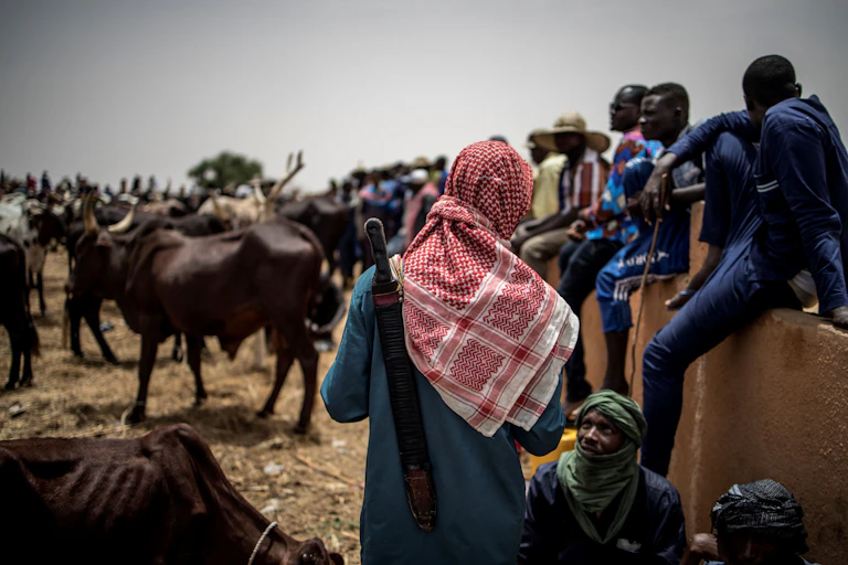 Herders chatting as they gather at a cattle market.