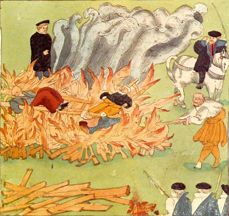 An illustration depicting witches in the fire as a clergyman watches.